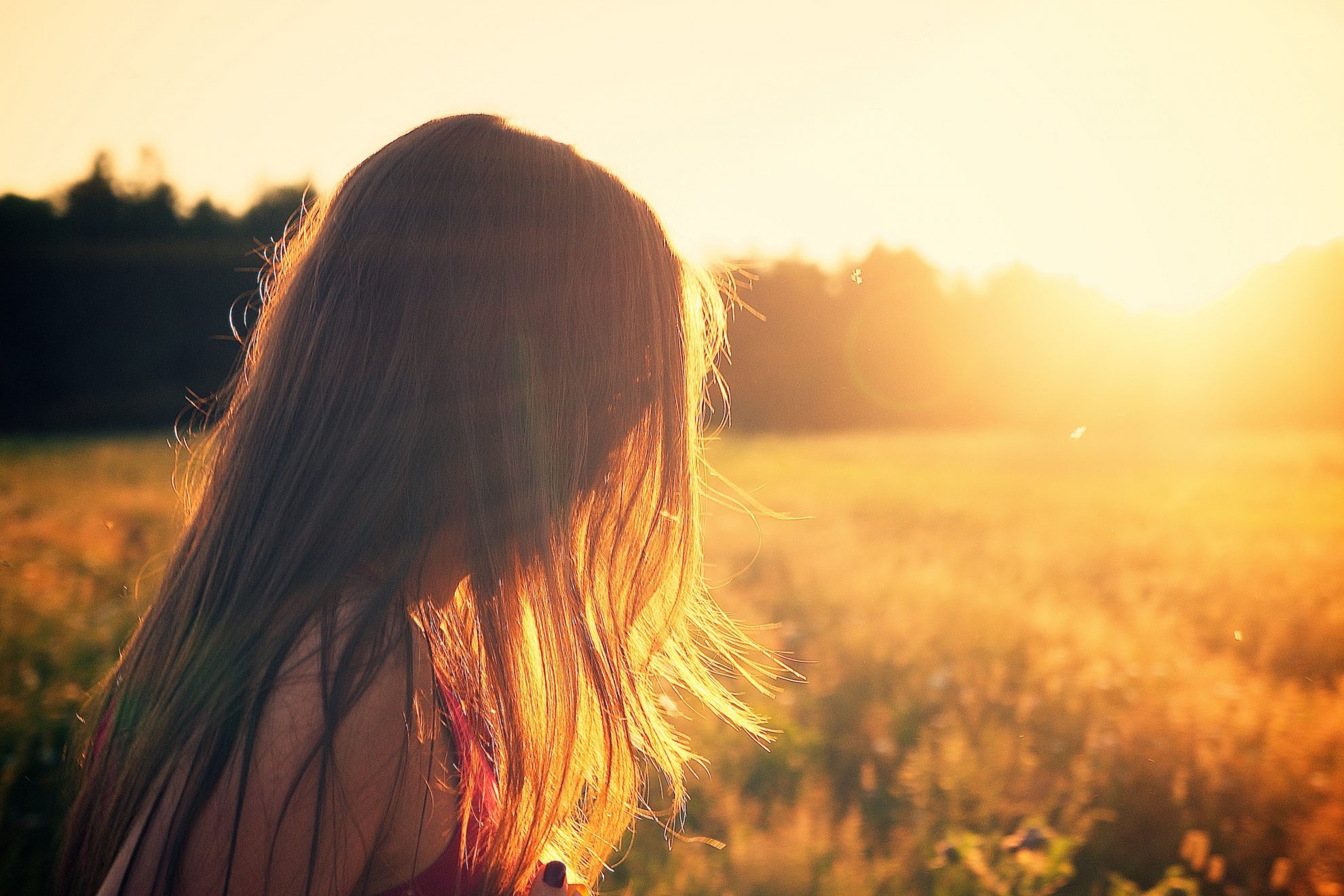 Frau auf einem Feld im Sonnenuntergang