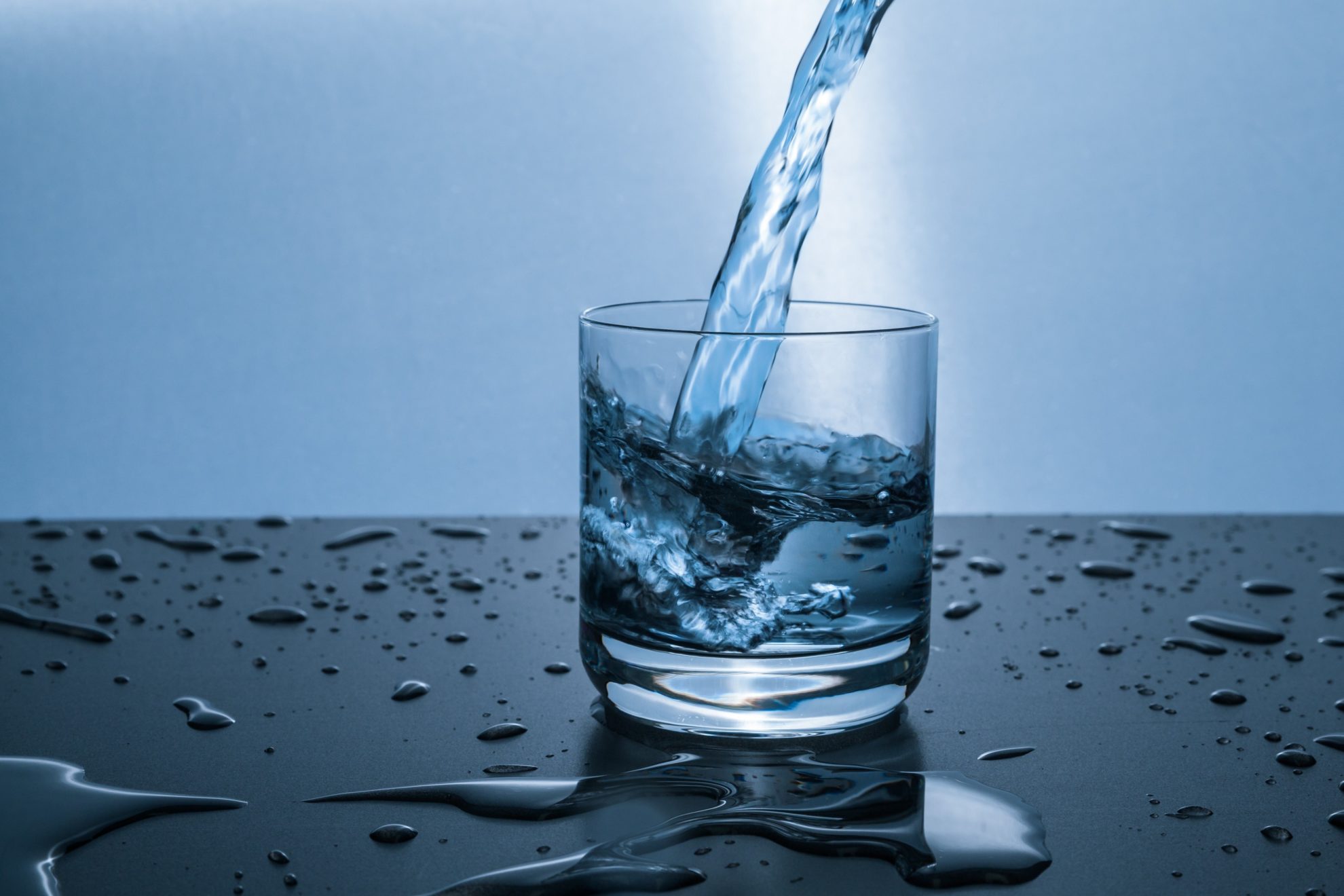 Wasser wird in ein Glas geschenkt