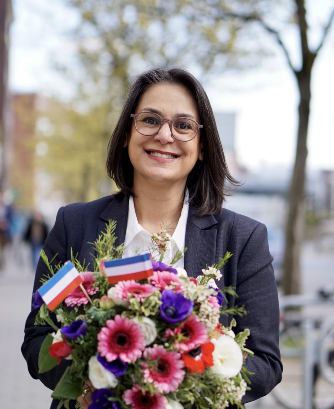 Serpil Midyatli. Frisch gewählt mit Blumenstrauß in Schleswig-Holstein Farben